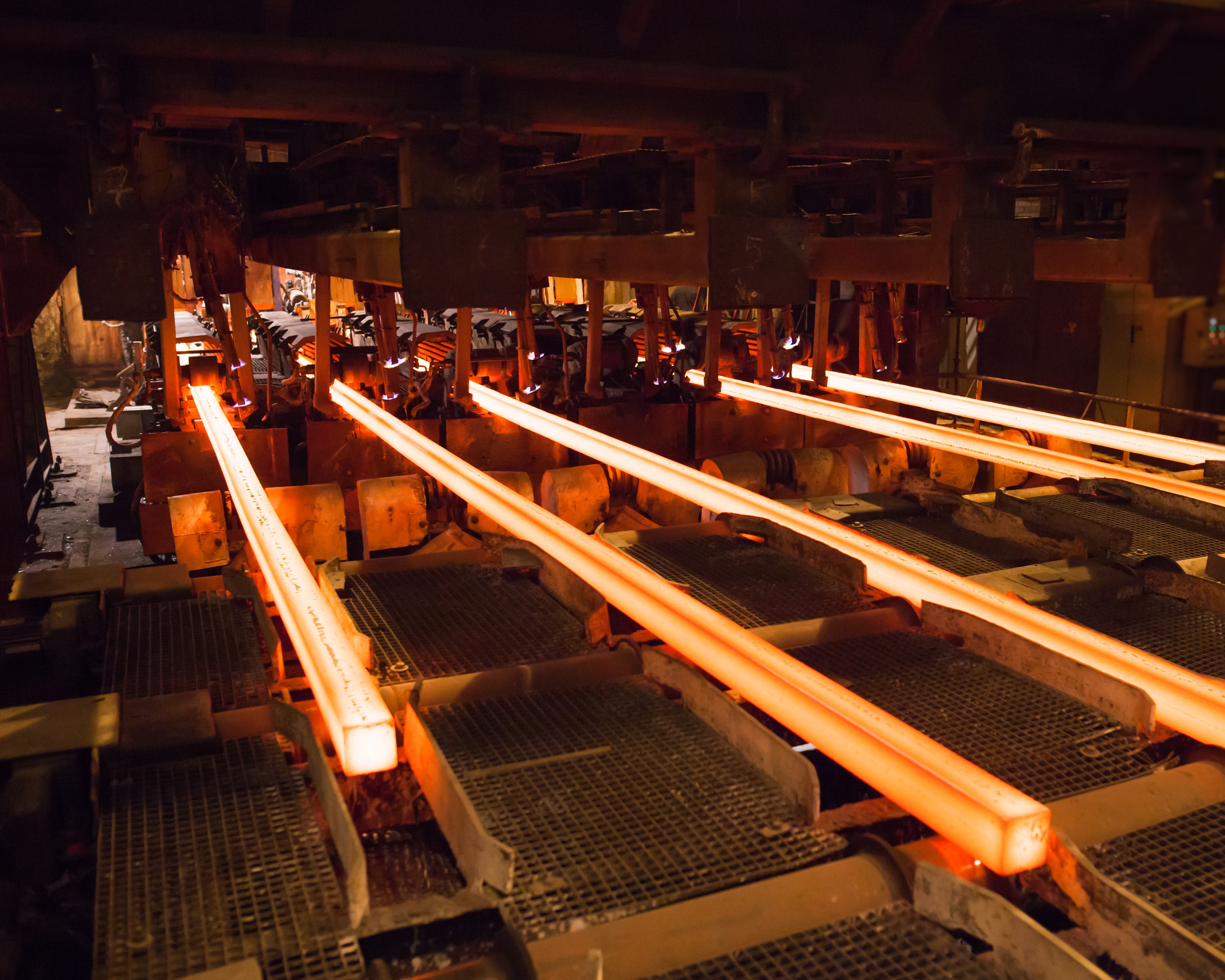 Machinery handling hot steel rods for bending purposes.