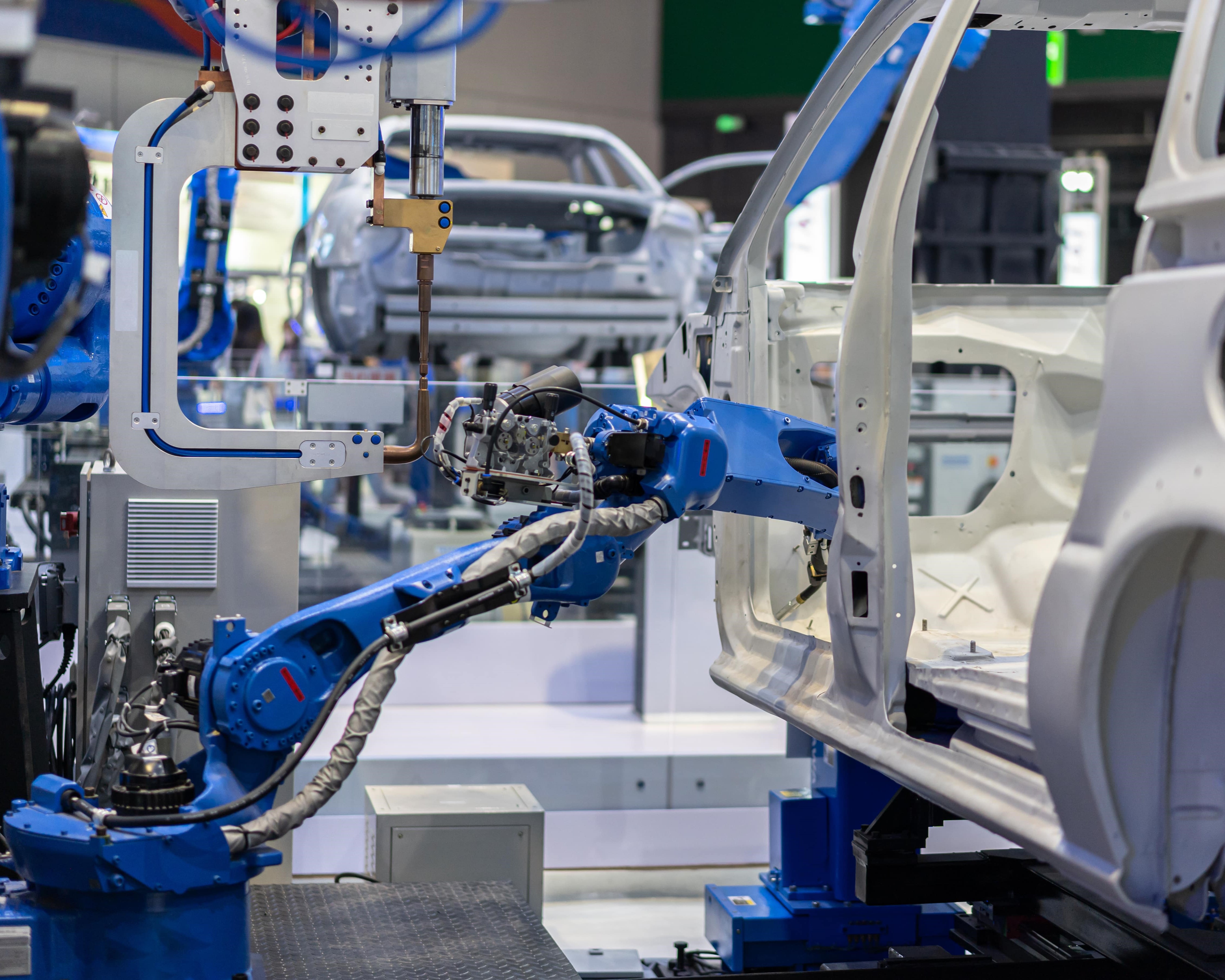 A scene of robots engaged in the assembly of a car, highlighting the integration of technology in automotive production.