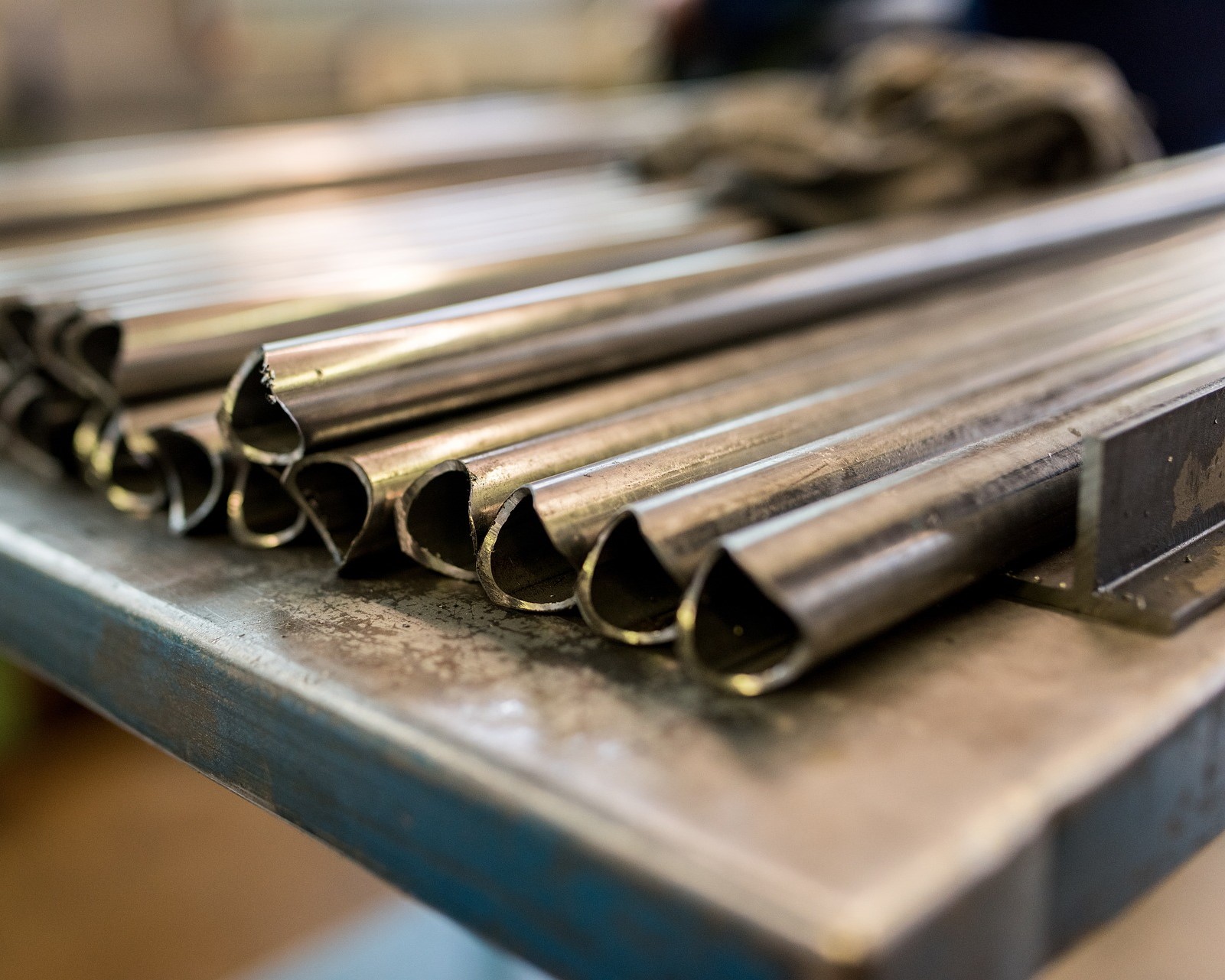 Metal rods layed out next to eachother on a workbench.